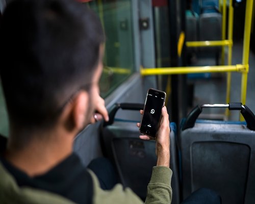 person commuting on public transport looking at smartphone